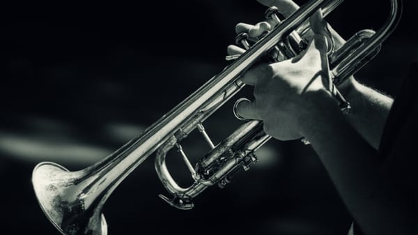Image: person holding a trumpet; Article: 7 Challenging Wynton Marsalis Trumpet Songs