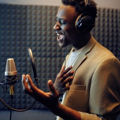 man singing into mic at a studio